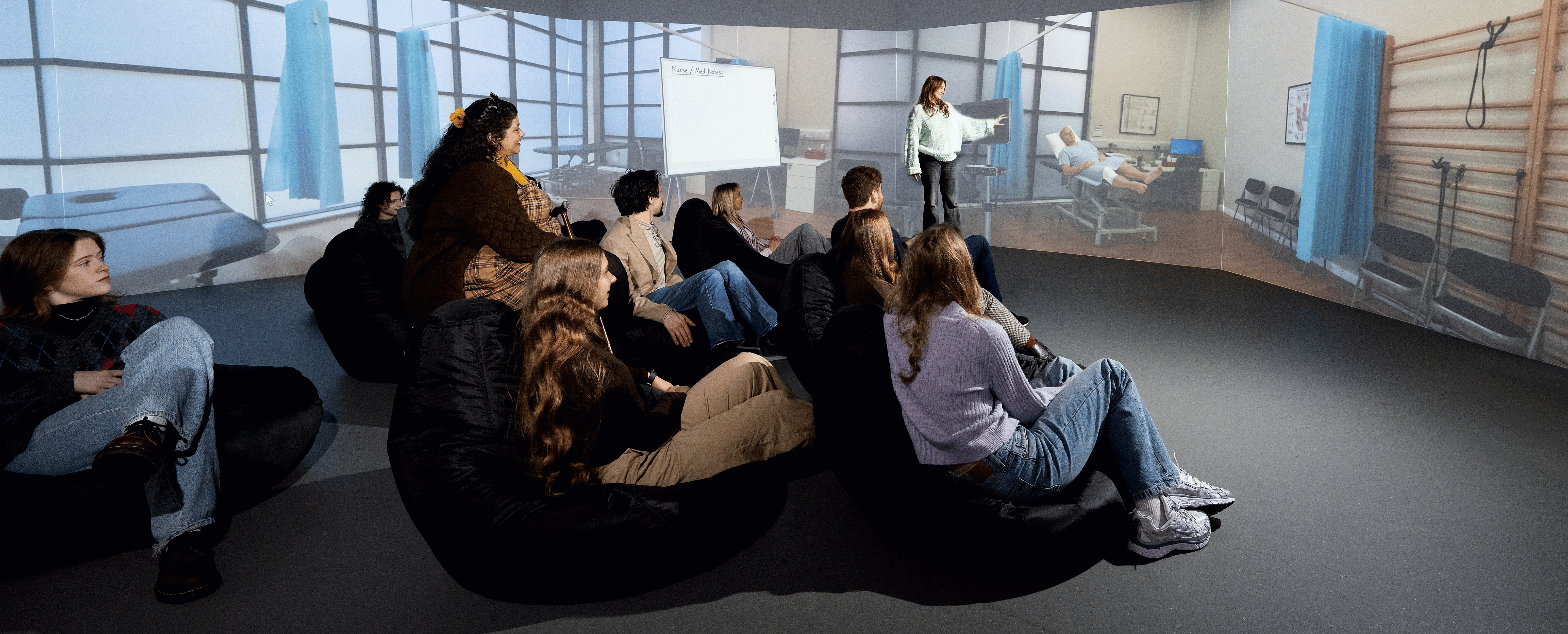 This is an image of students in the simulation lab, looking at the 360 physio therapy experience